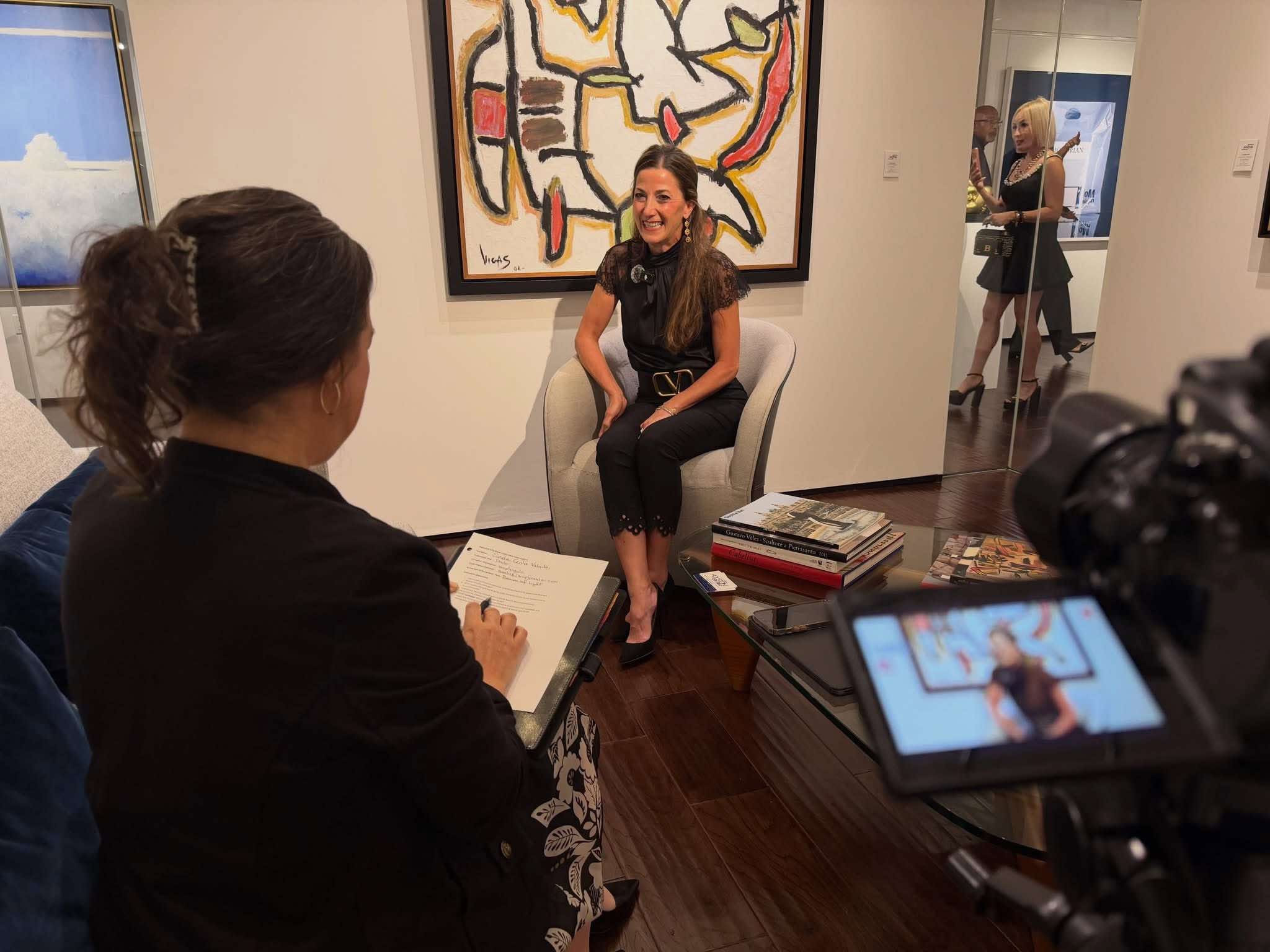 Saula Centa Valente seated for an Arrival Awards interview, with an interviewer and camera in the foreground.