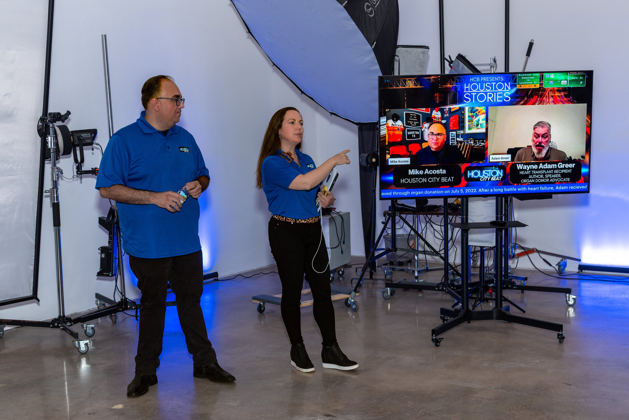 Two presenters beside an HCB display and studio equipment during the October 15 gathering.