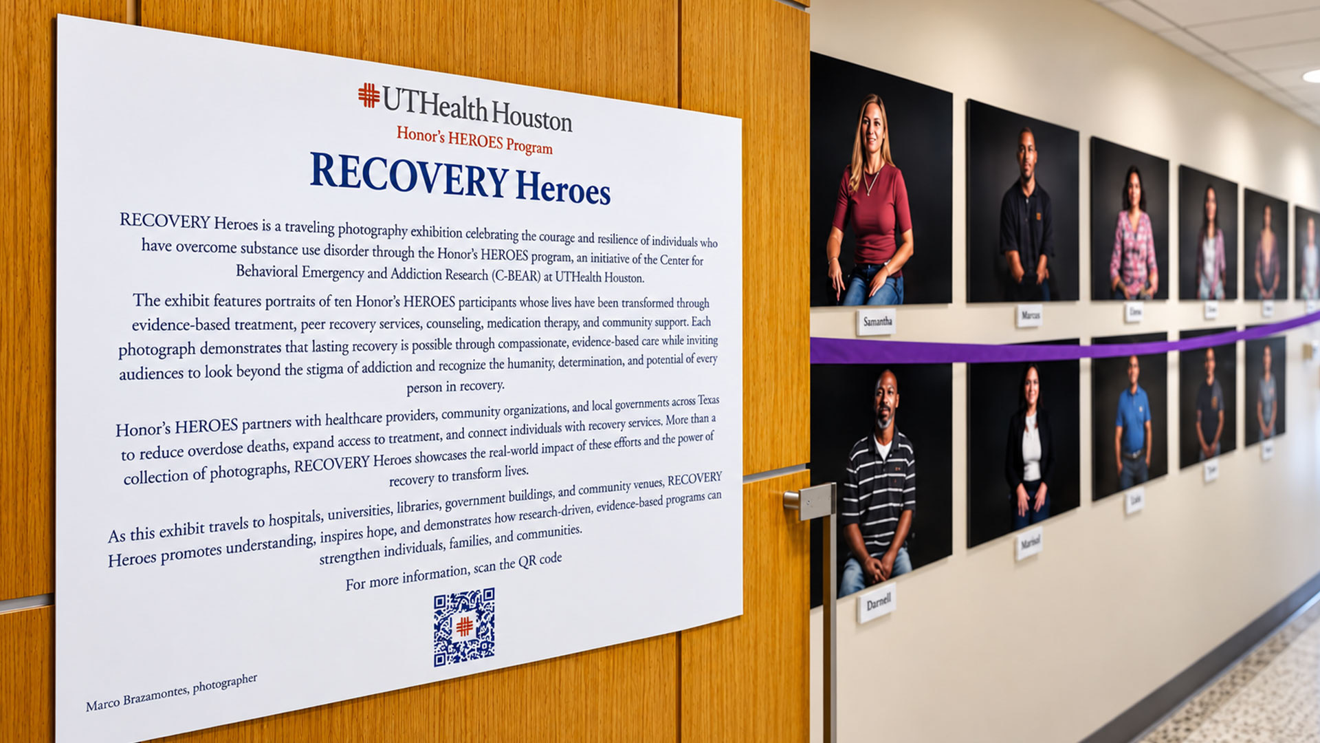 RECOVERY Heroes exhibition sign beside two rows of portrait photographs on a hallway wall.